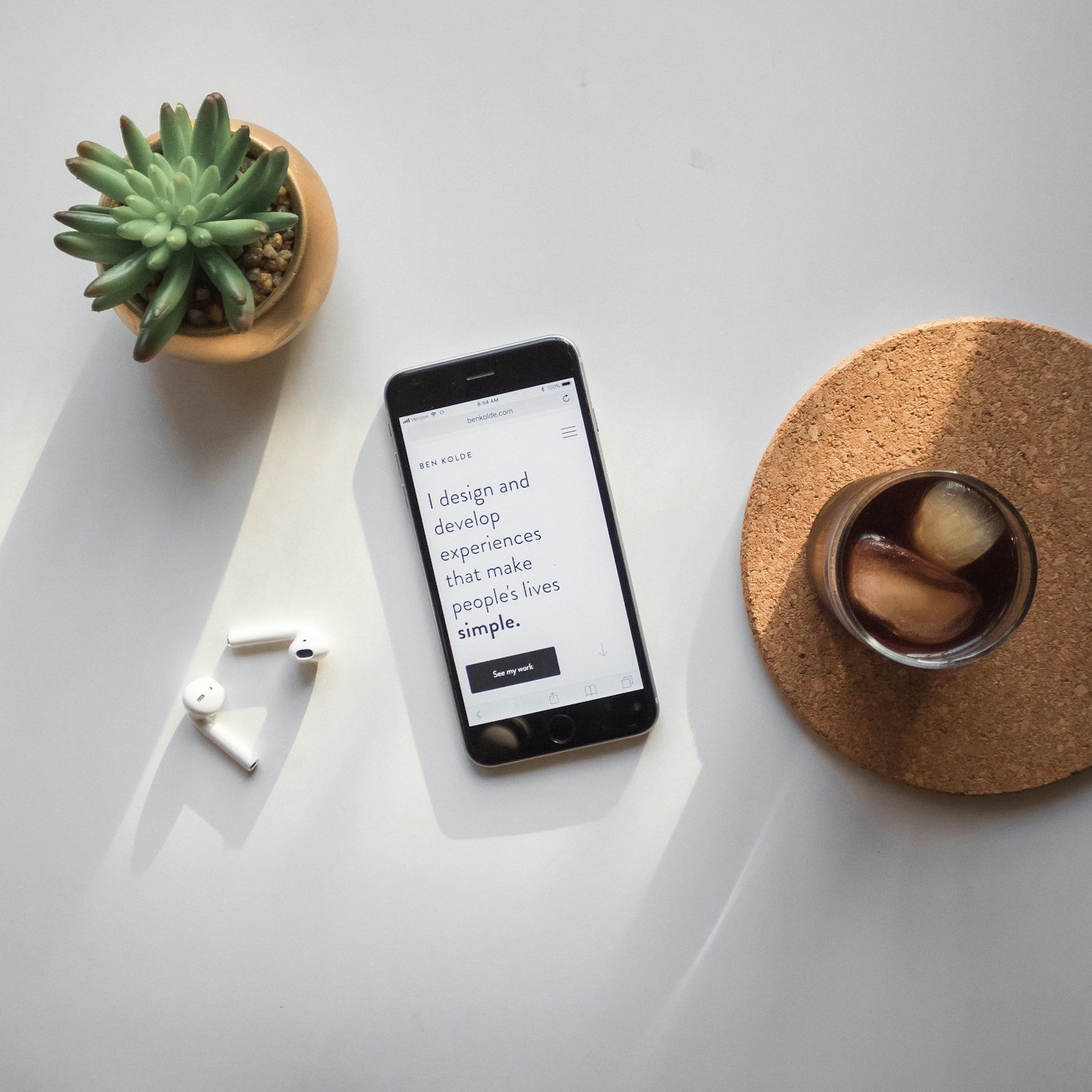 Smartphone met portfolio website op een opgeruimd bureau.