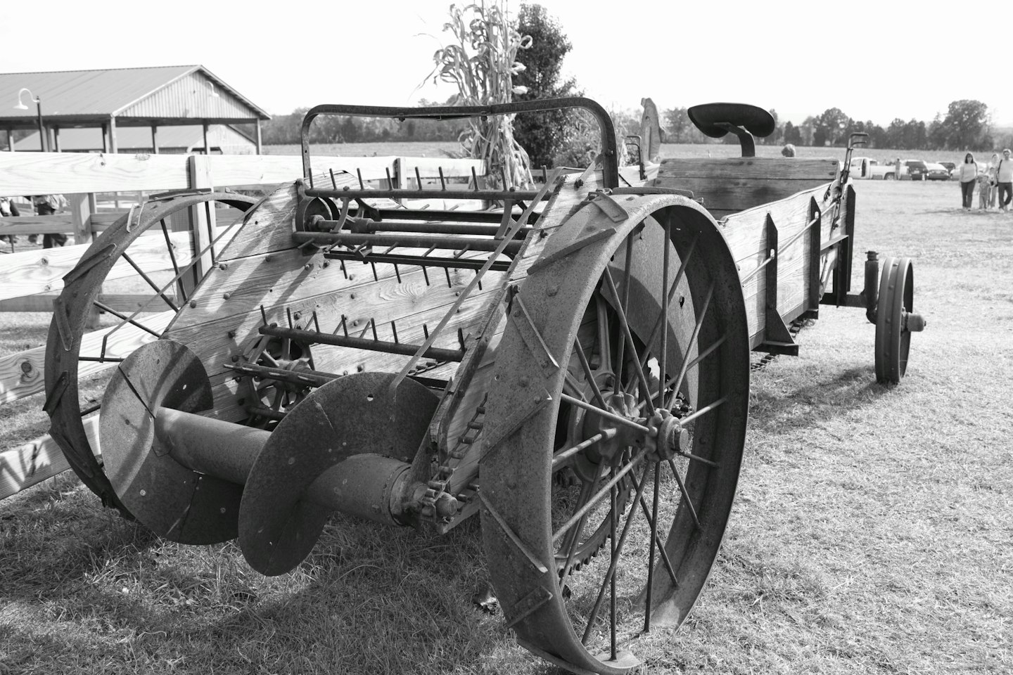 Antieke landbouwmachines met grote spaakwielen staan in een grasveld.